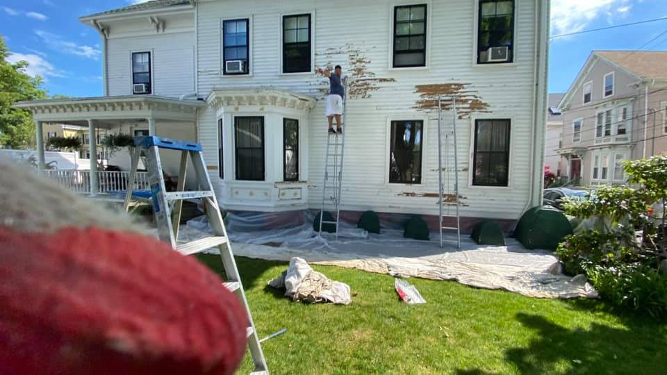Exterior house painting job in progress in Massachusetts.